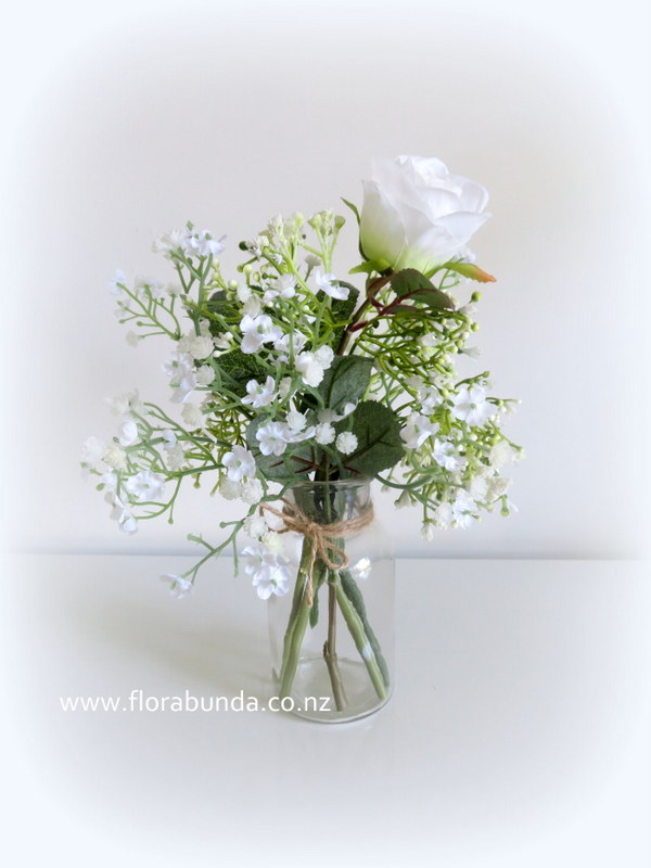 Baby's breath and whiye rose in bottle of artificial table flowers