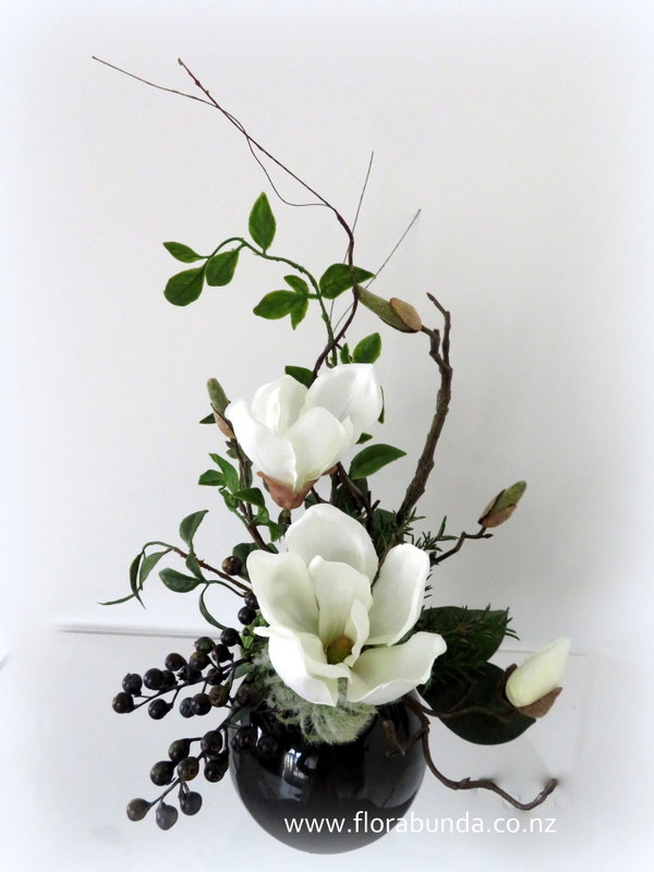 White magnolia flowers in black bowl.