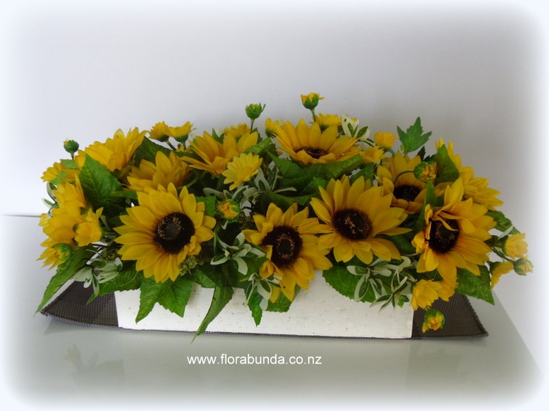 Yellow sunflower long low graveside arrangement